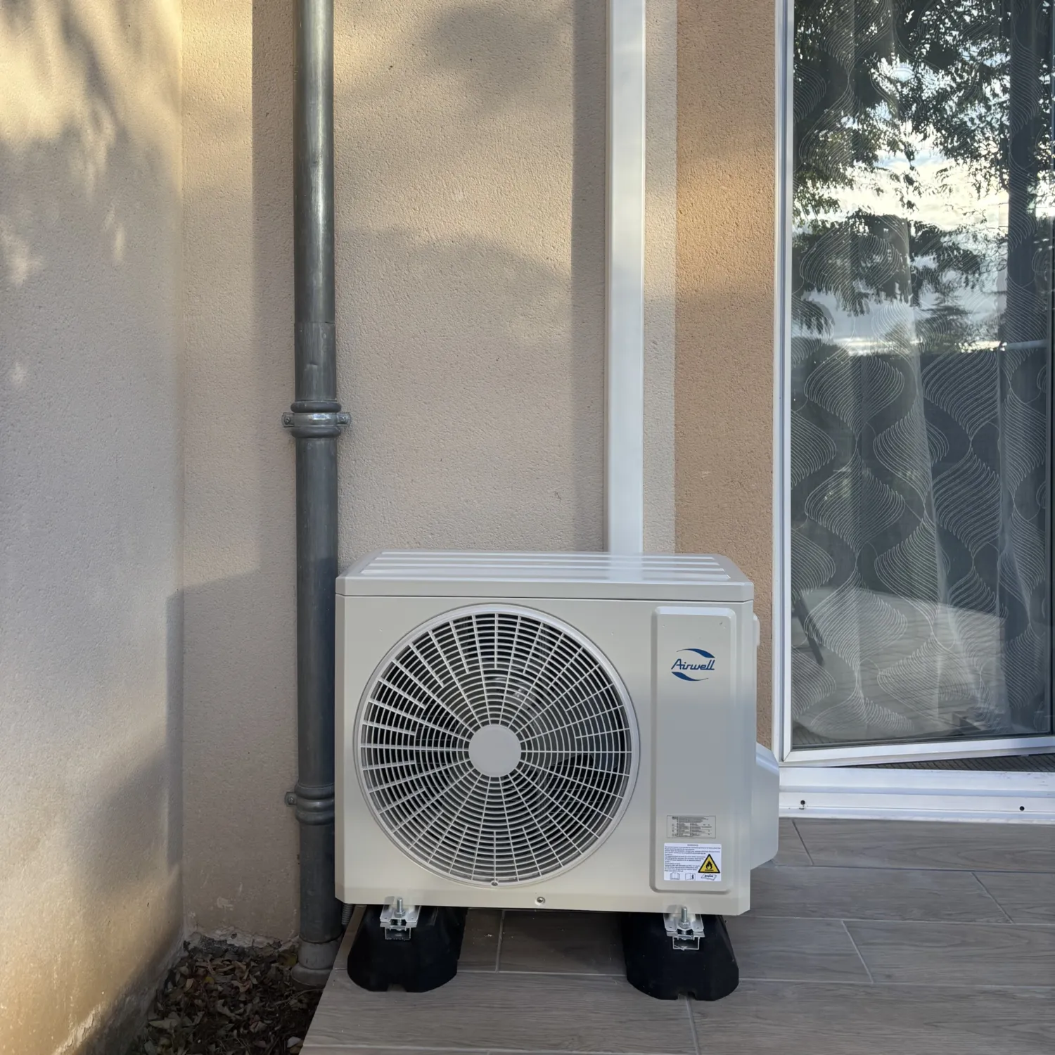 Réalisations - climatisation réversible- unite-exterieure-climatisation-airwell-terrasse-maison-foix - HG Habitat
